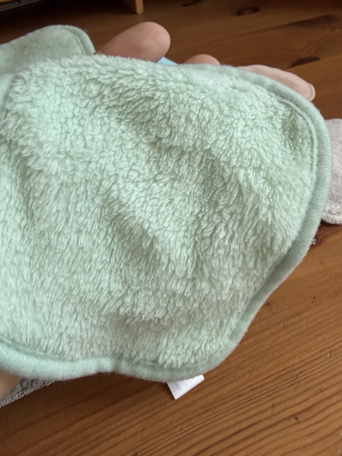 Gros plan d’un carré lavable vert en polyester à la texture polaire.